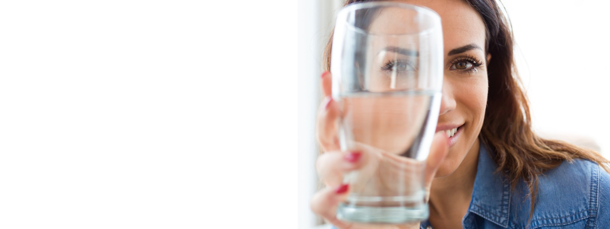 A smilling women, handling transparent water glass